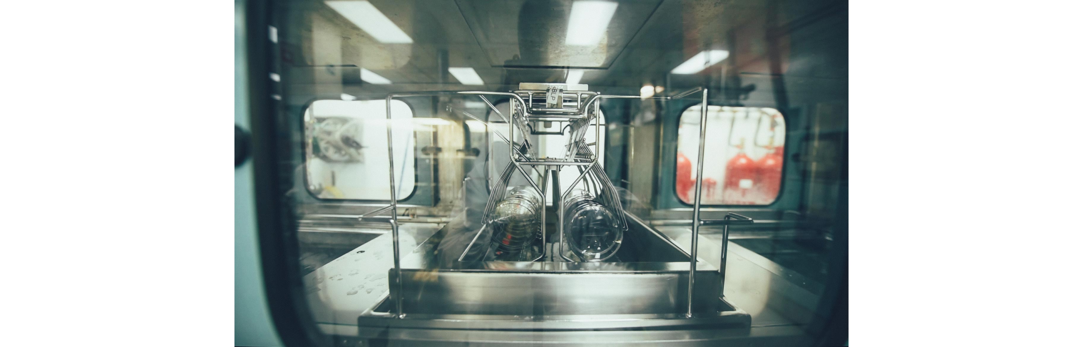 round Nikon lenses are in a machine and being soaked in a chemical solution to coat them according to the patient's needs