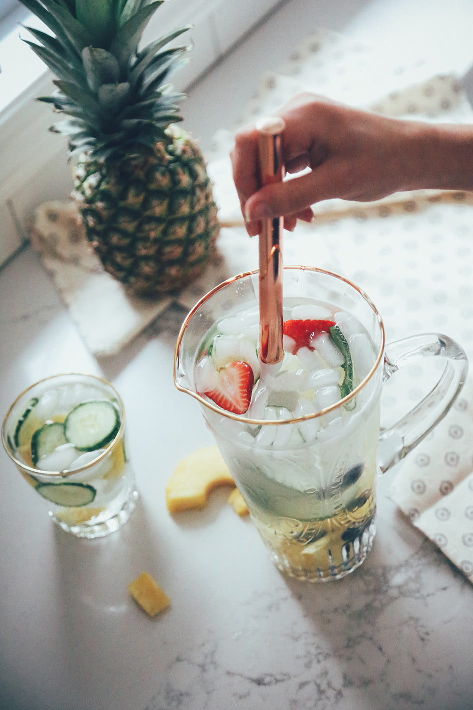 Two glasses of water with strawberries, cucumber and blueberries