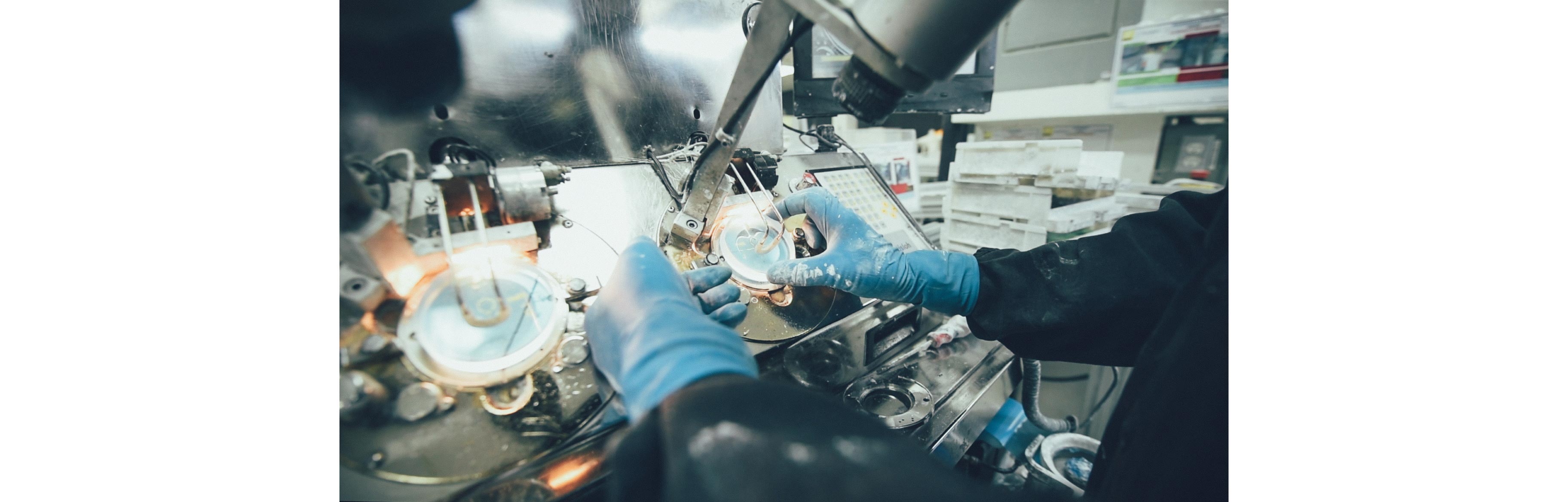 Un employé portant des gants s'affaire à polir les lentilles Nikon